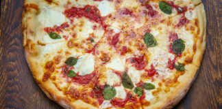 New York style Margherita pizza with fresh mozzarella and basil leaves