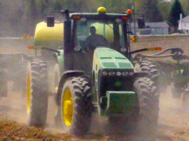 tractor plowing field kicking up dust