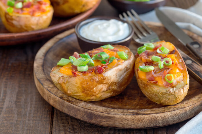 Baked loaded potato skins with cheddar cheese and bacon, garnish