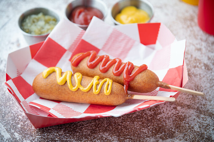 corn dog with ketchup and yellow mustard