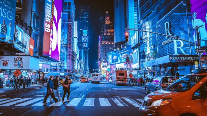 Photo by Andreas Niendorf people walking on pedestrian lane during night time