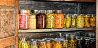 a wooden shelf filled with lots of jars of food